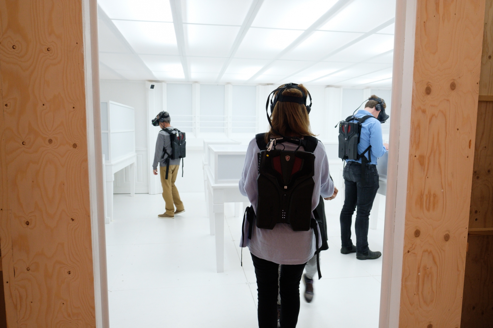 Ausstellungsbesucher mit VR-Brillen vor augenscheinlich leeren Wänden