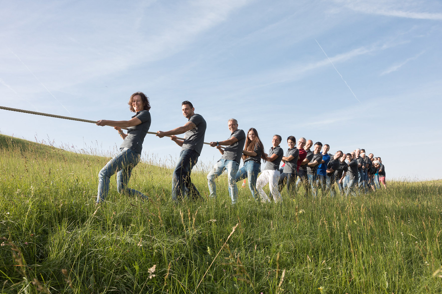 MBA team at a tug-of-war in a meadow